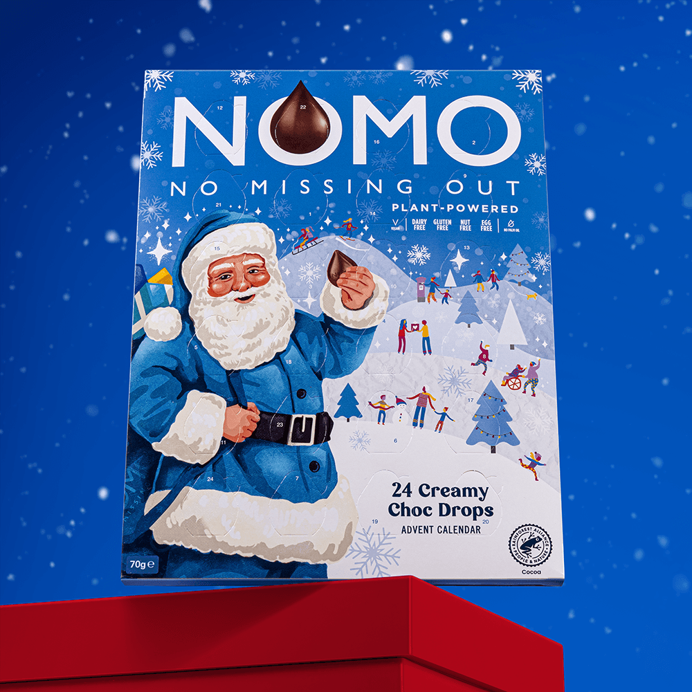 Nomo Plant-Powered Advent Calendar chocolate box featuring a festive Santa Claus illustration, displayed on a red pedestal against a blue snowy background.